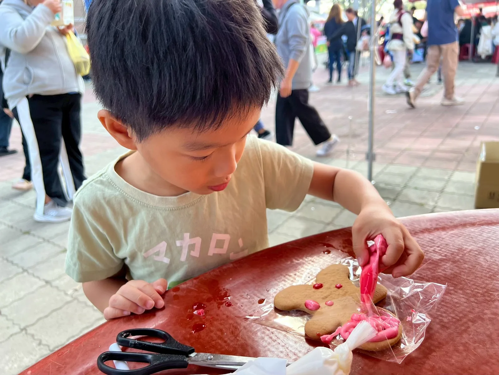 孩子在歲末市集專注畫薑餅人